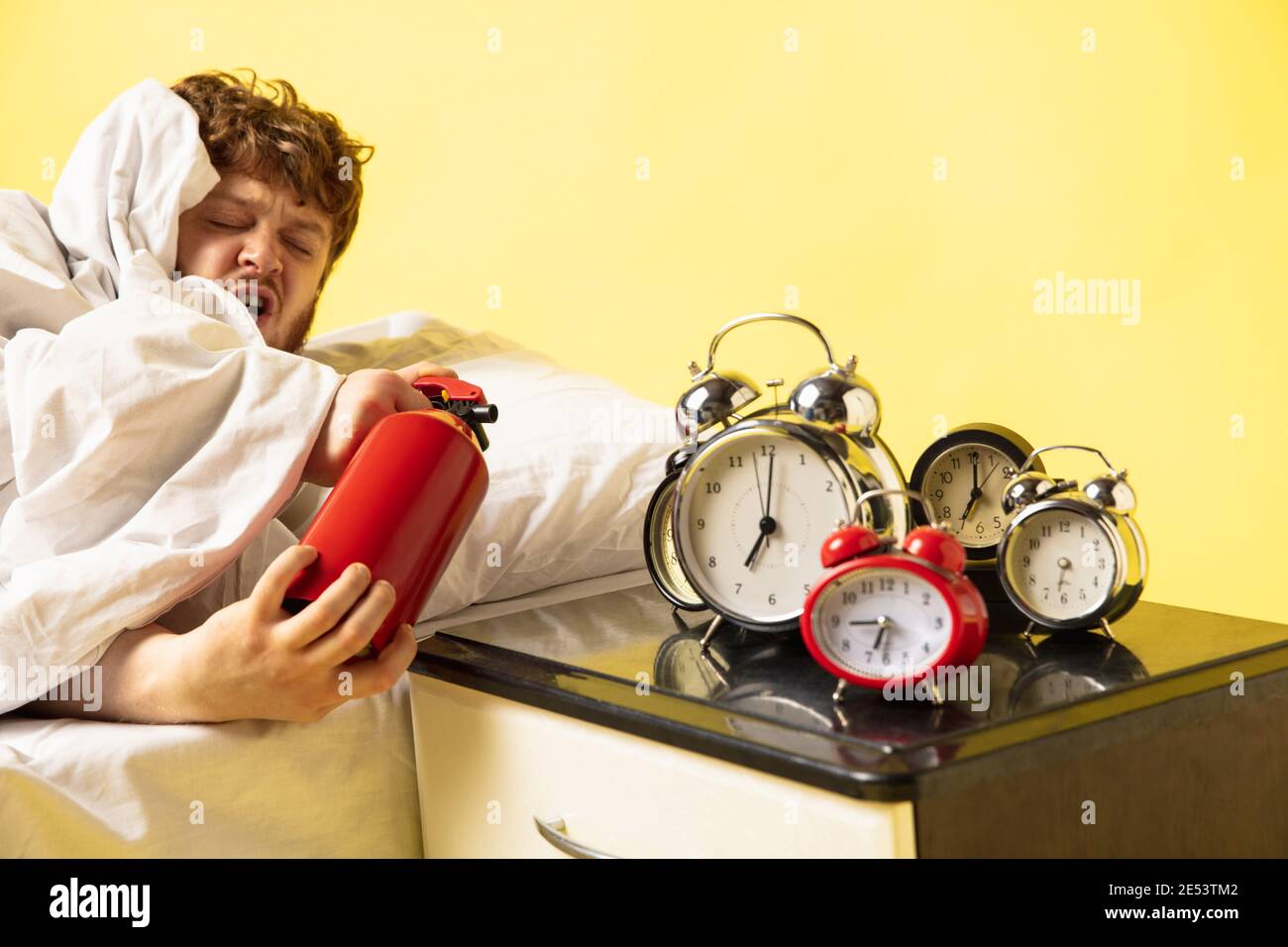 L'uomo si sveglia sul suo letto su sfondo giallo ed è impazzito quando gli  orologi suonano, lo spegne con l'estintore. Persone che odiano mattina,  duro risveglio, odio, emozioni folli, tardi al lavoro