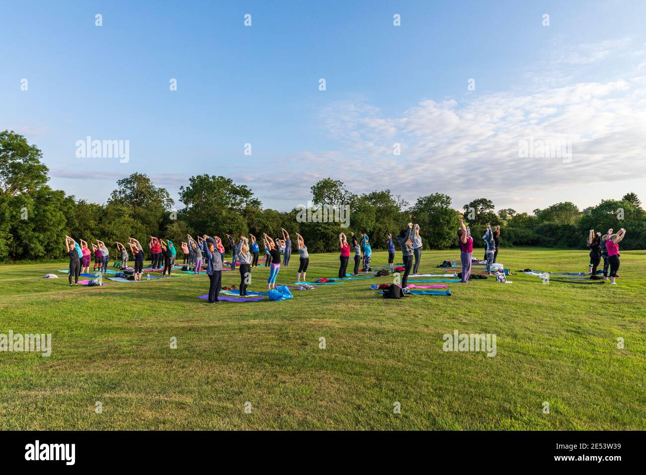 Lezione di yoga all'aperto al tramonto in un ambiente naturale Foto Stock