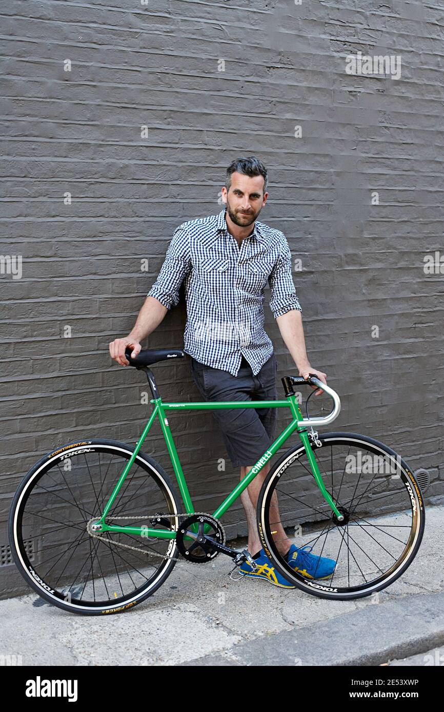 Uomo in piedi di fronte a Green Vintage Bicycle Foto Stock