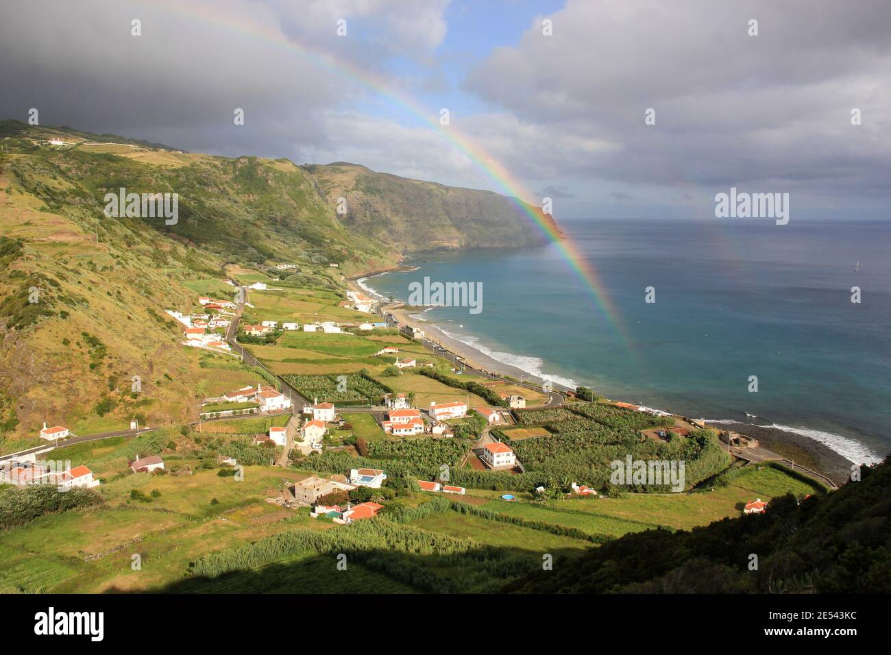 Isola di Santa Maria, paesaggio con arcobaleno, piccolo villaggio, montagne, baia, Azzorre. Foto Stock