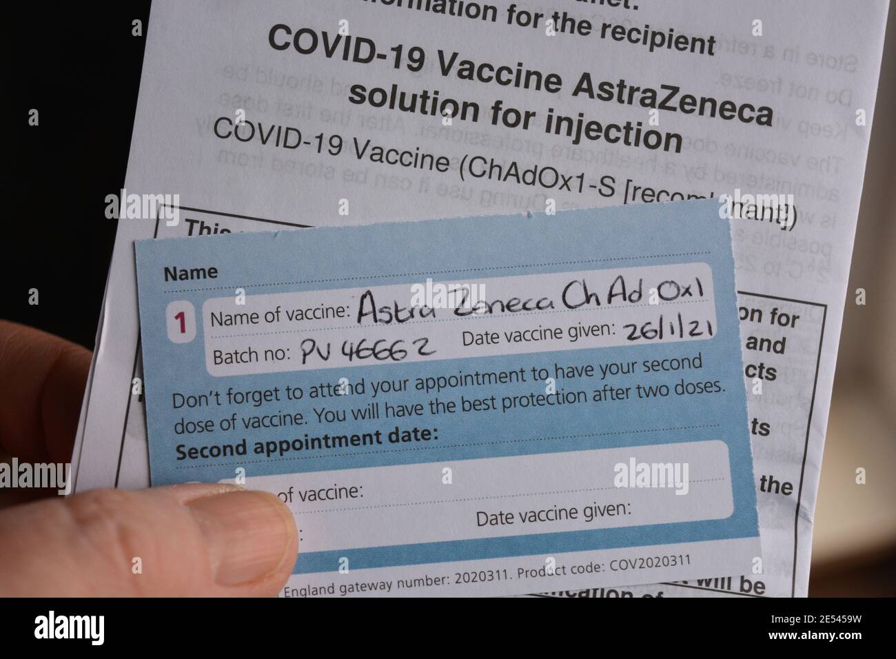 Vaccino Covid-19 AstraZeneca card in mano, che mostra la partita e la data del primo vaccino somministrato, con informazioni per i destinatari, Somerset, Inghilterra Foto Stock