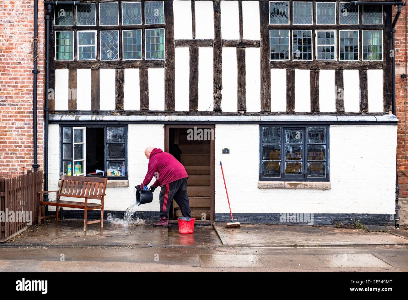 Bewdley, Worcestershire, Regno Unito. 26 gennaio 2021. Le acque alluvionali si defondono dopo che la città di Bewdley, Worcestershire, è stata parzialmente allagata dal fiume Severn. Un uomo si libera dall'acqua dal suo edificio secolare, che era sotto i cinque piedi di acqua alluvionata quando le difese del fiume fallirono. Credit: Peter Lopeman/Alamy Live News Foto Stock