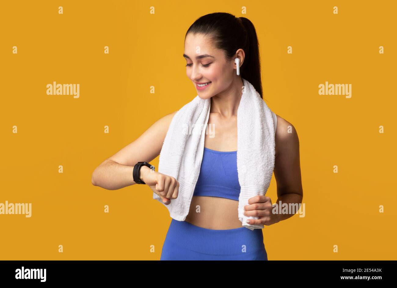 Smiling giovane donna in Sportswear controllo attività Tracker Foto Stock