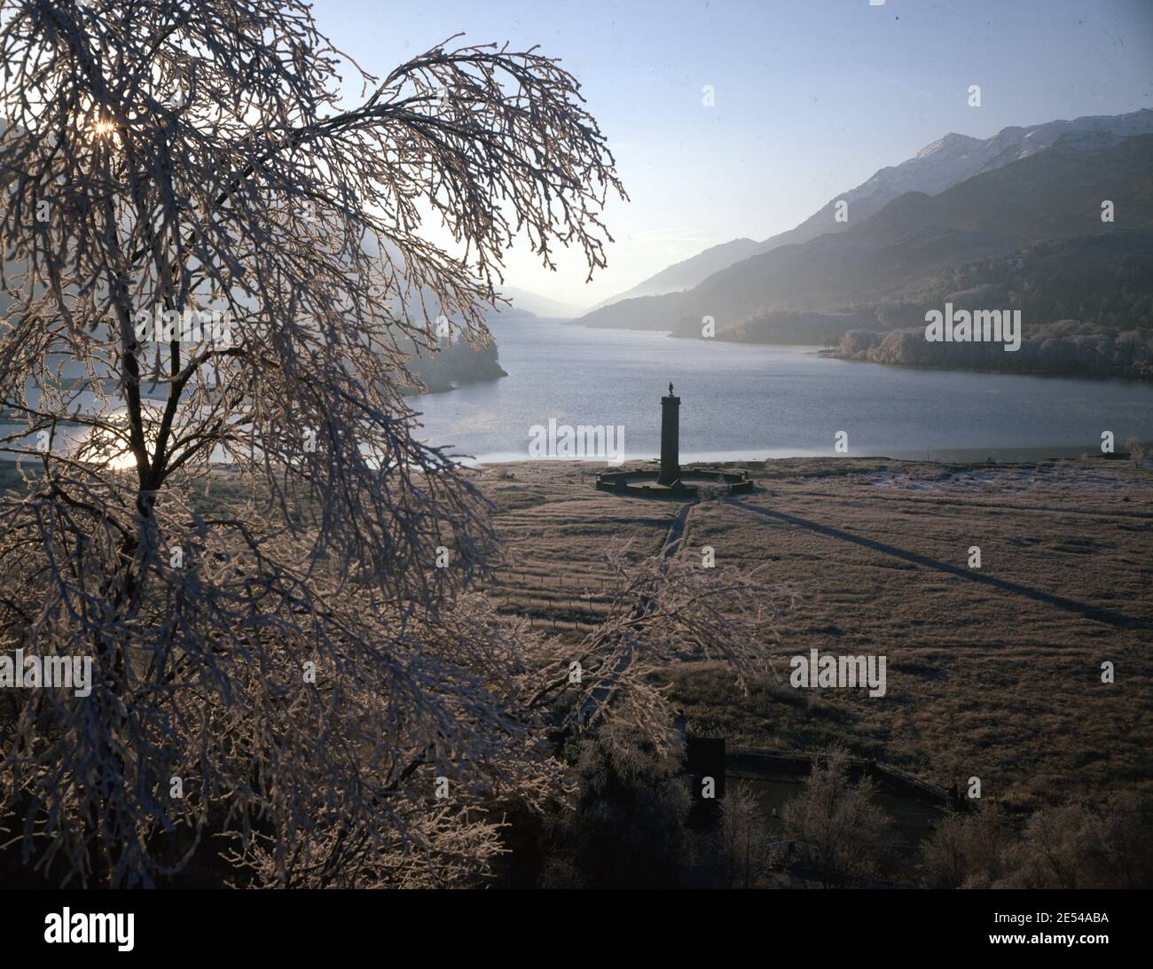 Scozia, Iverness-Shire. Mattina ghiacciata di Loch Shiel con brina di semente spessa sulla betulla. Con il monumento di Glenfinnan in piedi alto, nel 1745 la rivolta giacobita iniziò a Glenfinnan, quando il principe Charles Edward Stuart ('Bonnie Prince Charlie') innalzò il suo standard sulle rive di questo lago. Nel 1815, il 60 m (18 piedi) Glenfinnan Monument, alla testa del lago, è stato eretto per commemorare quell'evento storico.Foto scattata nel 1980 circa. Foto di Tony Henshaw/Tom Parker Collection Scansionato da una trasparenza originale di 5'x4' da un archivio unico e stupefacente di fotografia originale del Briti Foto Stock