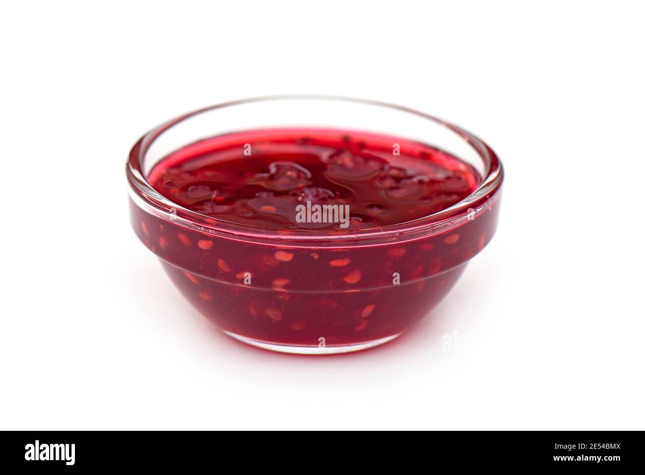 Marmellata di lamponi in recipiente di vetro, inceppamento liquido isolato su bianco, vista laterale, disposizione con spazio per il testo Foto Stock