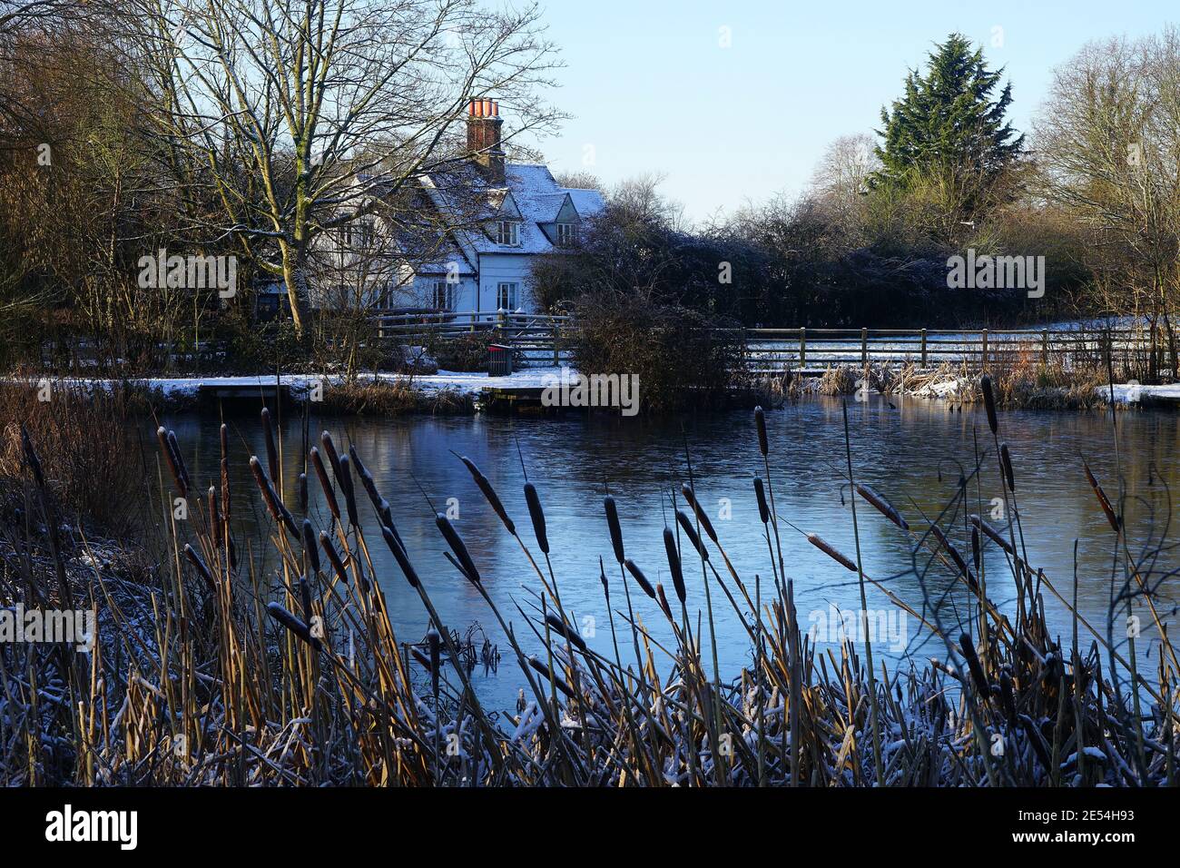 Cottage vicino a un frozen Willan Pond nella neve di gennaio Foto Stock