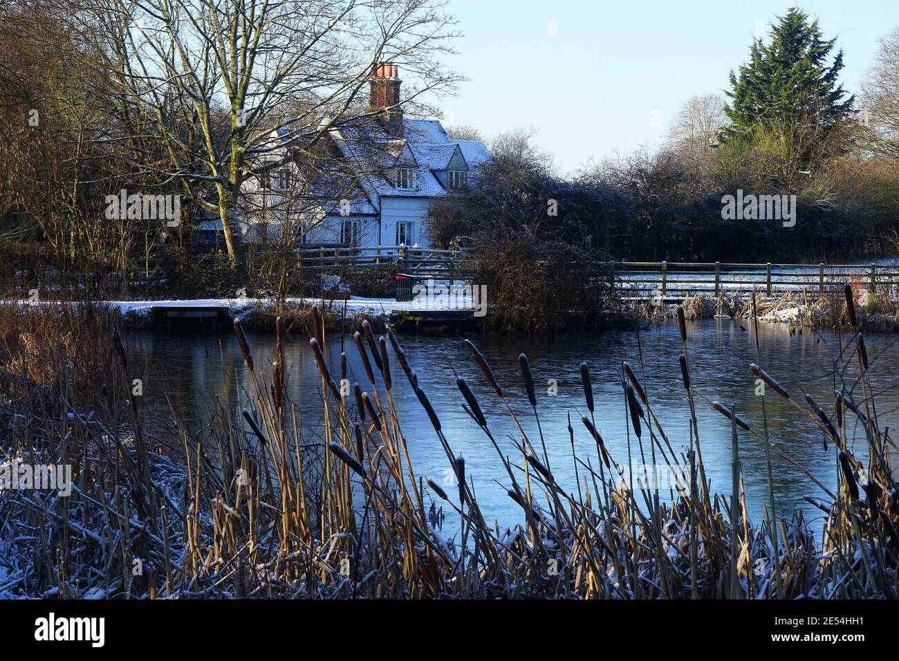 Cottage vicino a un frozen Willan Pond nella neve di gennaio Foto Stock