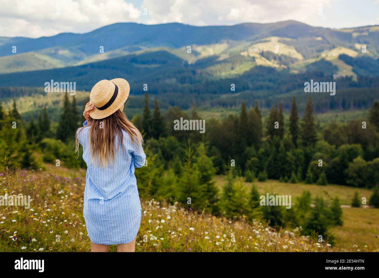 Viaggiare in primavera Ucraina. Gita ai Monti Carpazi. Giovane turista donna rilassarsi in fiori ammirando la vista. Escursioni Foto Stock