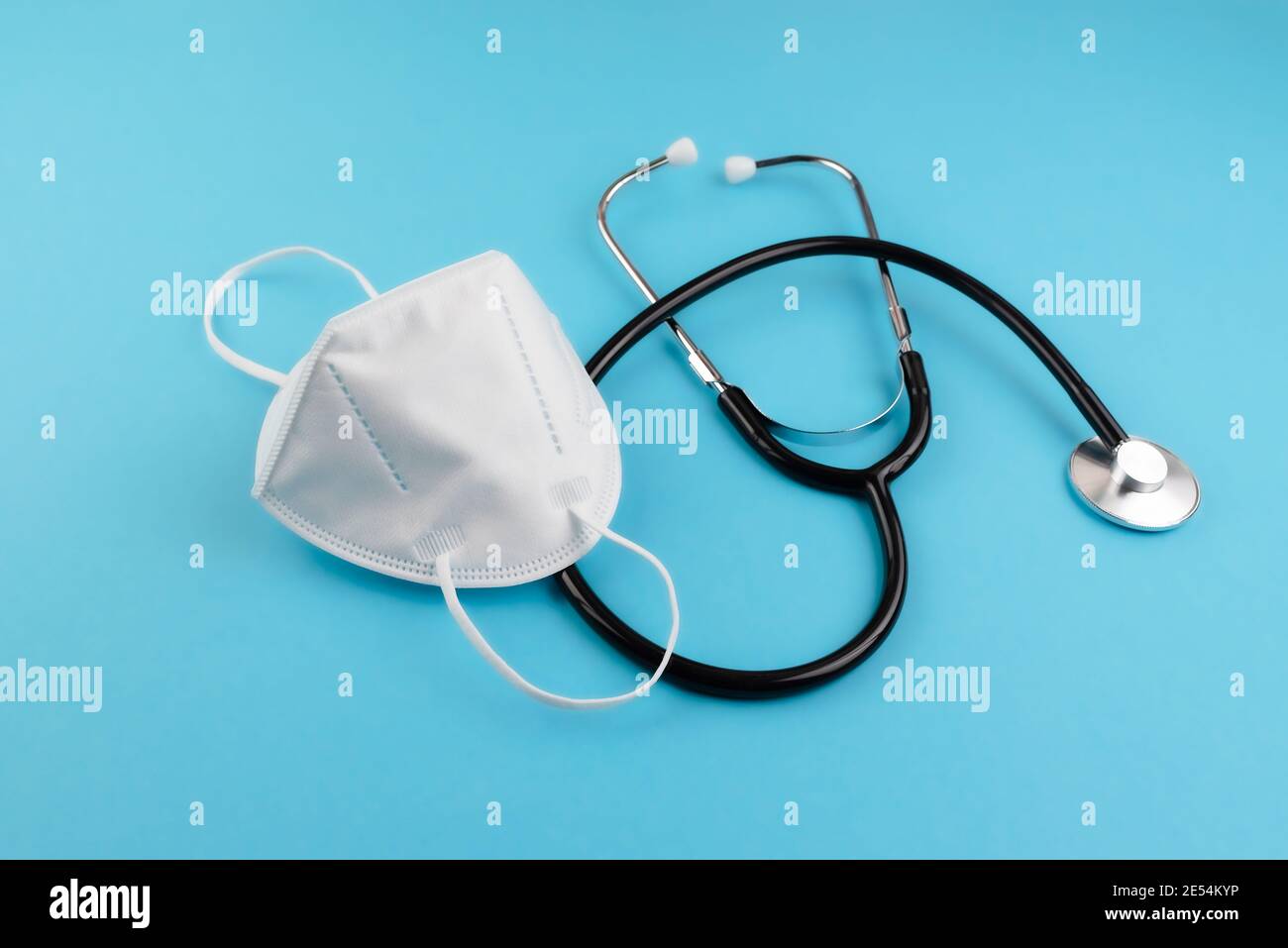 vista ad angolo alto dello stetoscopio e del respiratore ffp2 su sfondo blu, concetto di coronavirus e malattie respiratorie covid-19 Foto Stock