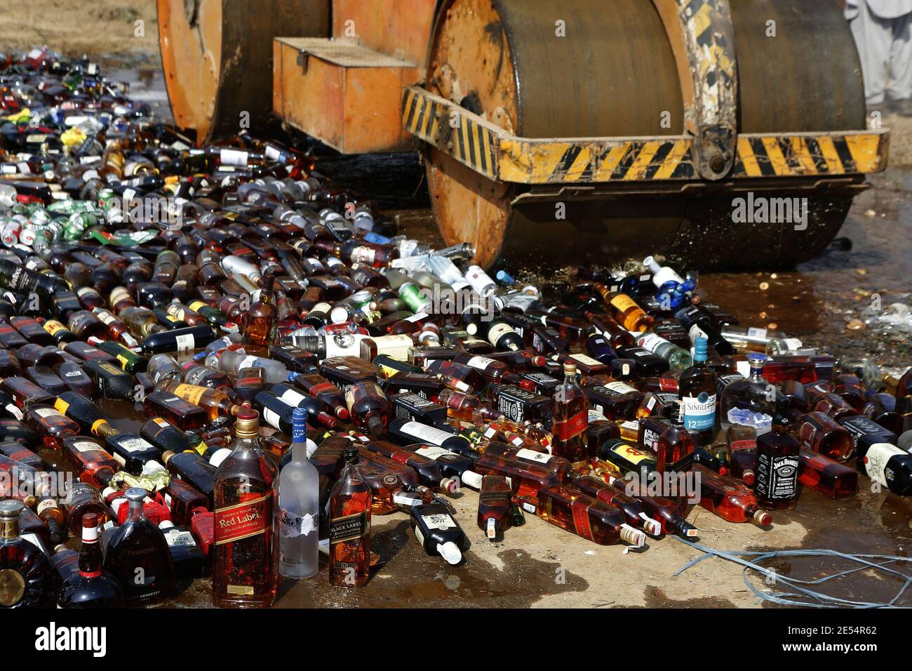 Funzionari doganali che distruggono le bottiglie di alcol e bruciano le droghe sequestrate durante la cerimonia della combustione della droga, alla vigilia della Giornata doganale internazionale Foto Stock