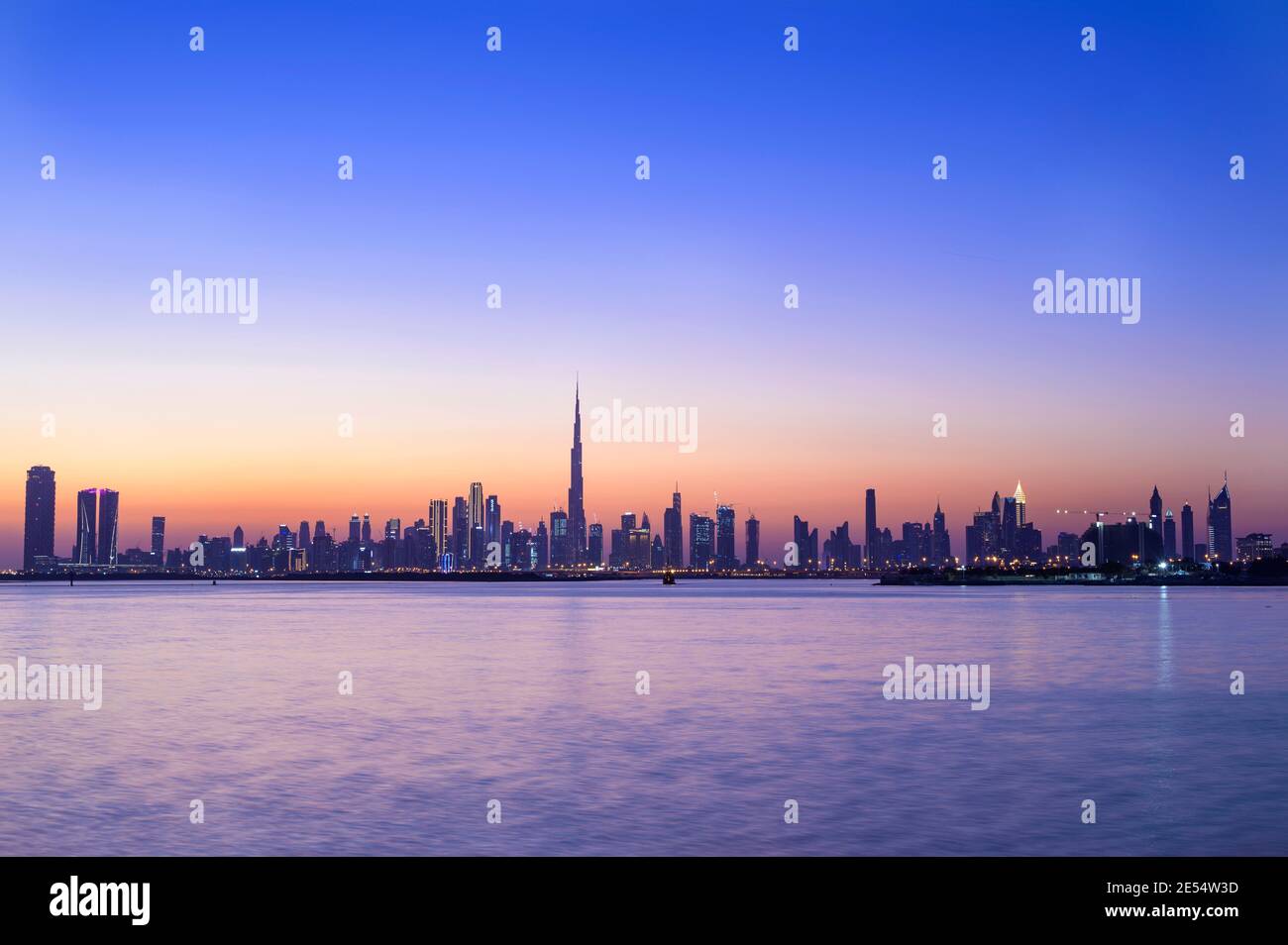 Vista panoramica dello skyline di Dubai con Burj khalifa e. altri raschiatori di cielo catturati al tramonto con il bello Cielo blu al torrente di Dubai Foto Stock