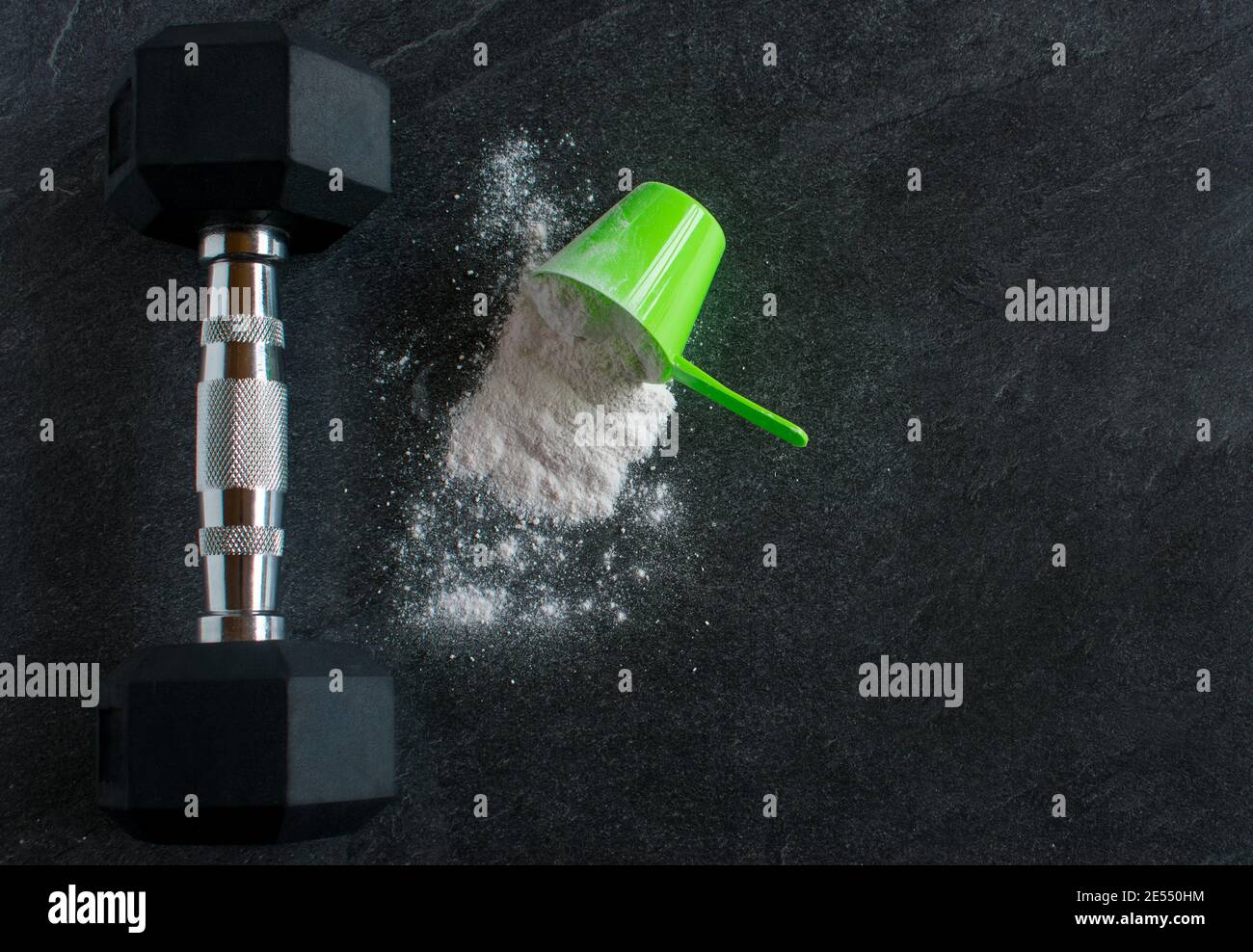 Dumbbell con un mucchio di polvere proteica di siero di latte al buio sfondo dall'alto Foto Stock