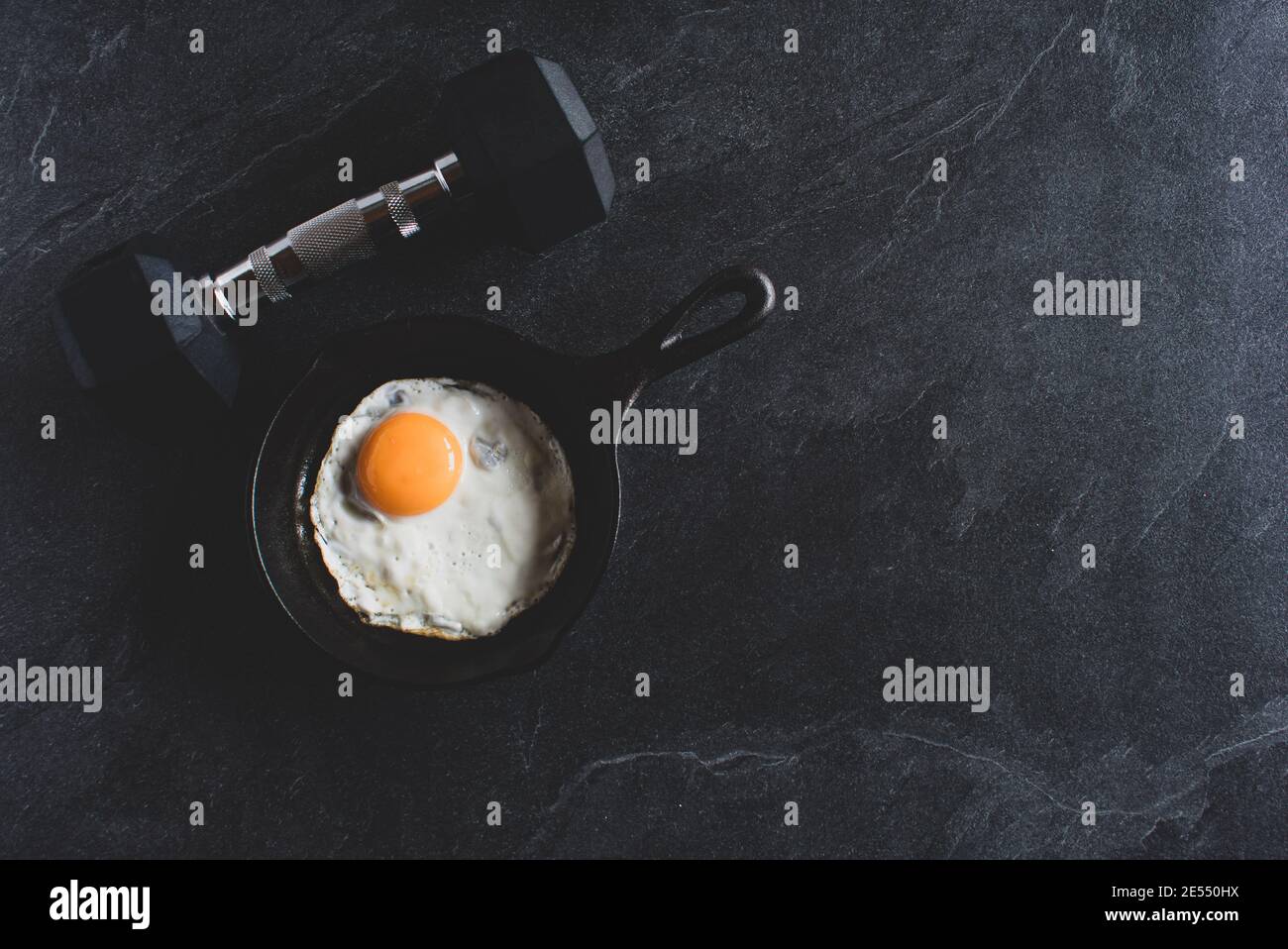 manubri con uova fritte in padella su sfondo scuro dall'alto con spazio per la copia Foto Stock