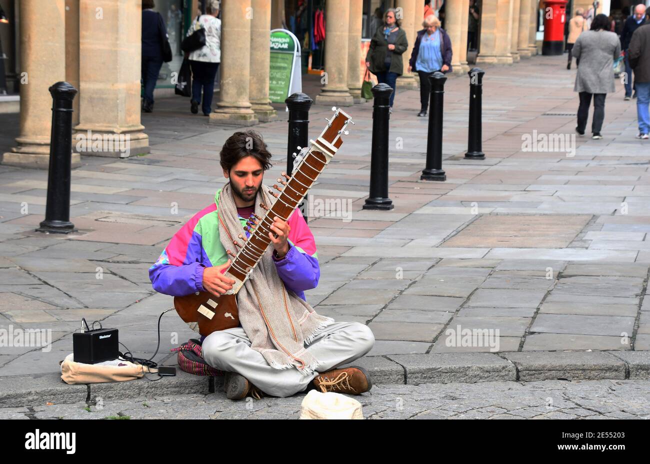 Concentrazione sul volto di musicista busking sul suo sitar nel centro della città di Bath in Somerset, Inghilterra. Foto Stock