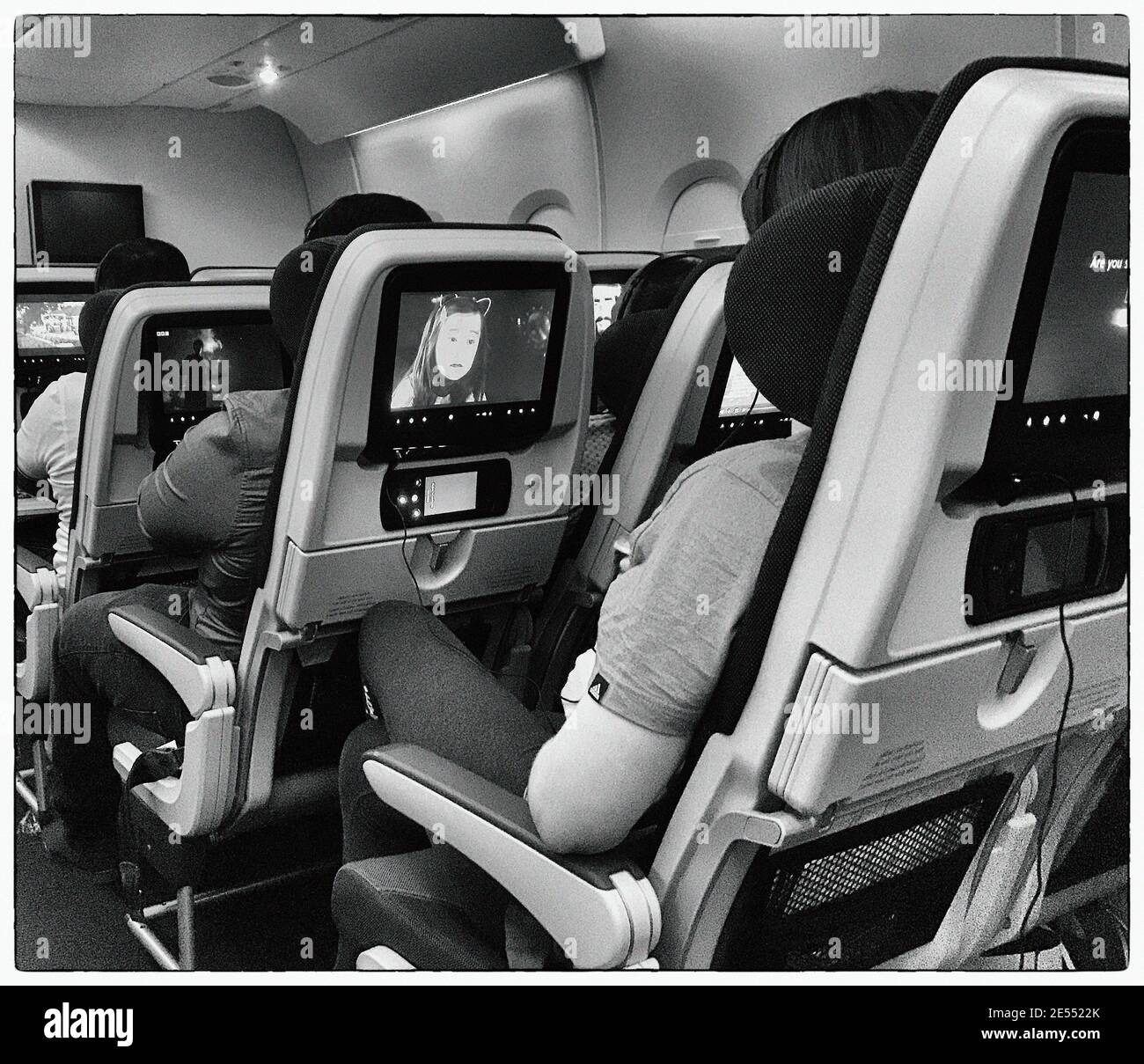 film in volo che gioca su un volo di linea aerea Foto Stock