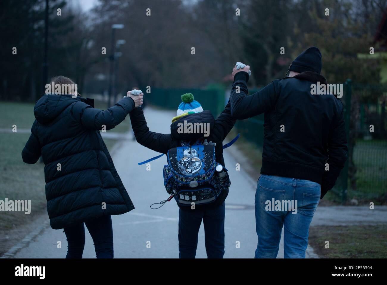 Lubiana, Slovenia. 26 gennaio 2021. Uno studente della scuola elementare sta per andare a scuola accompagnato dai suoi genitori a Lubiana, Slovenia, 26 gennaio 2021. Gli asili e i primi tre gradi di scuola primaria apriranno martedì in nove delle 12 regioni slovene, l'ufficio del primo ministro confermato ai media locali lunedì. Credit: Zeljko Stevanic/Xinhua/Alamy Live News Foto Stock