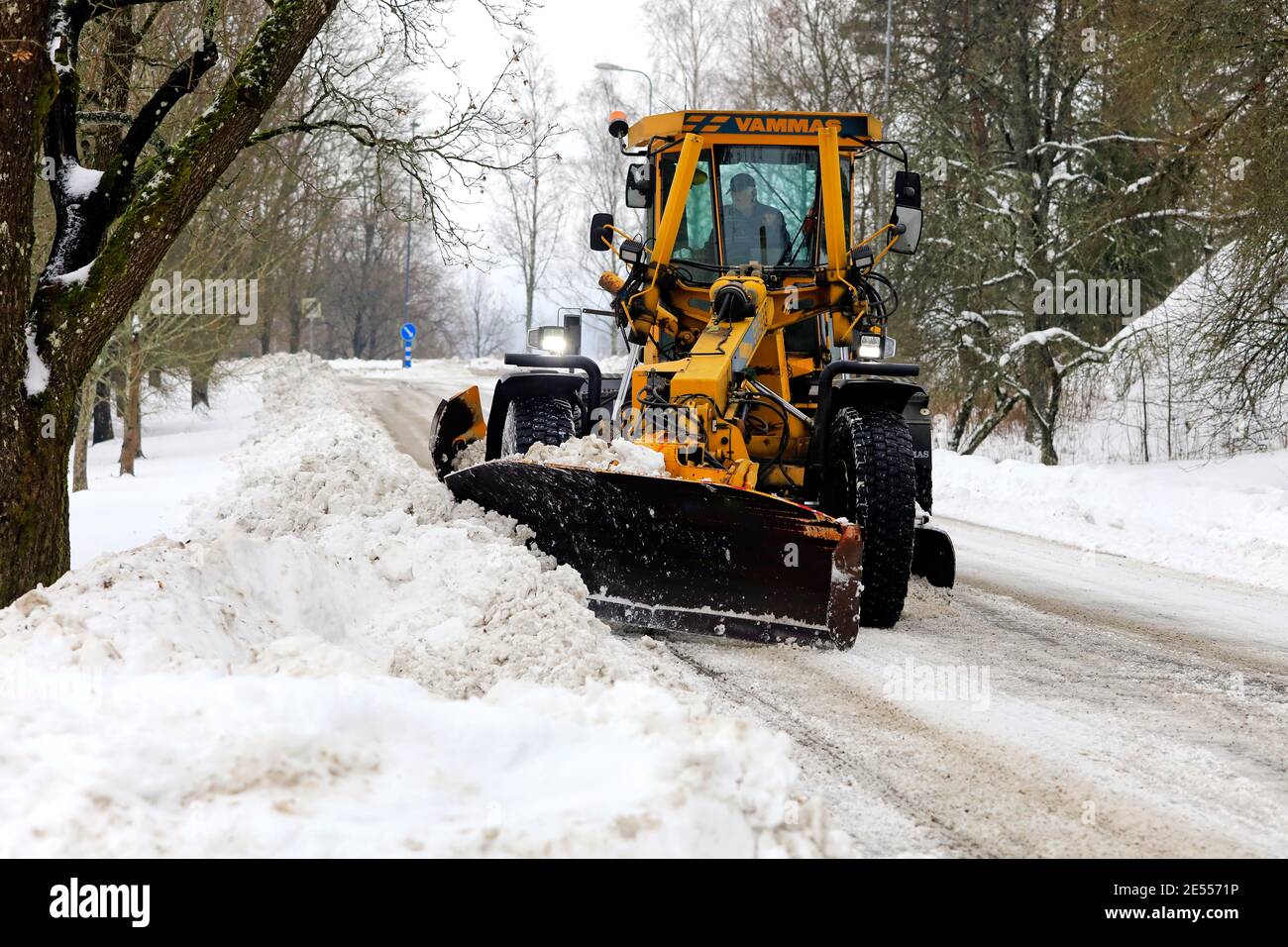 Motorgrader giallo Vamas che rimuove la neve dalla strada dopo una pesante nevicata a Salo, Finlandia. 22 gennaio 2021. Foto Stock