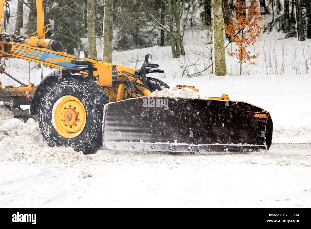 Motorgrader giallo Vamas rimozione della neve dalla strada in leggera nevicata. Dettaglio. Salo, Finlandia. 22 gennaio 2021. Foto Stock