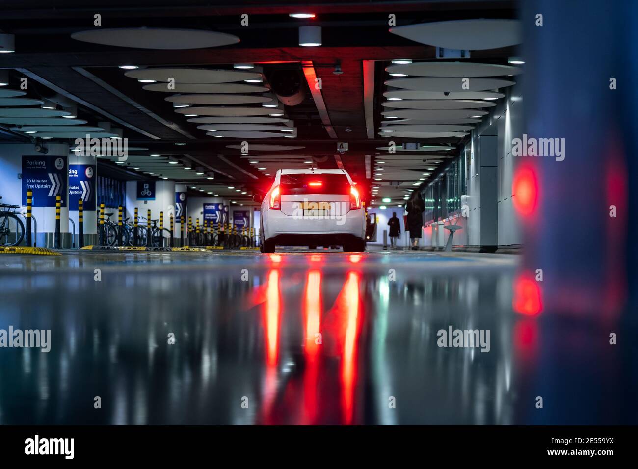 Taxi auto bianca trasporto pubblico in attesa di passeggeri pioggia allagato luci per la circolazione su strada luci di stop scure e vibranti per i clienti Foto Stock