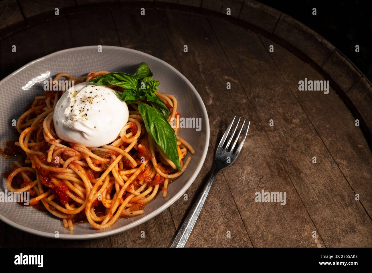 Piatto di spaghetti con mozzarella intera e basilico Foto Stock