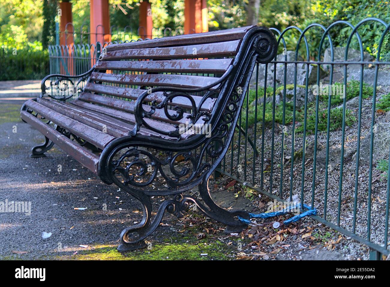 Banco bloccato alla recinzione metallica mediante catena per evitare movimenti e furti. Visto nel parco di St Stephen Green, Dublino, Irlanda. Morbido e selettivo Foto Stock
