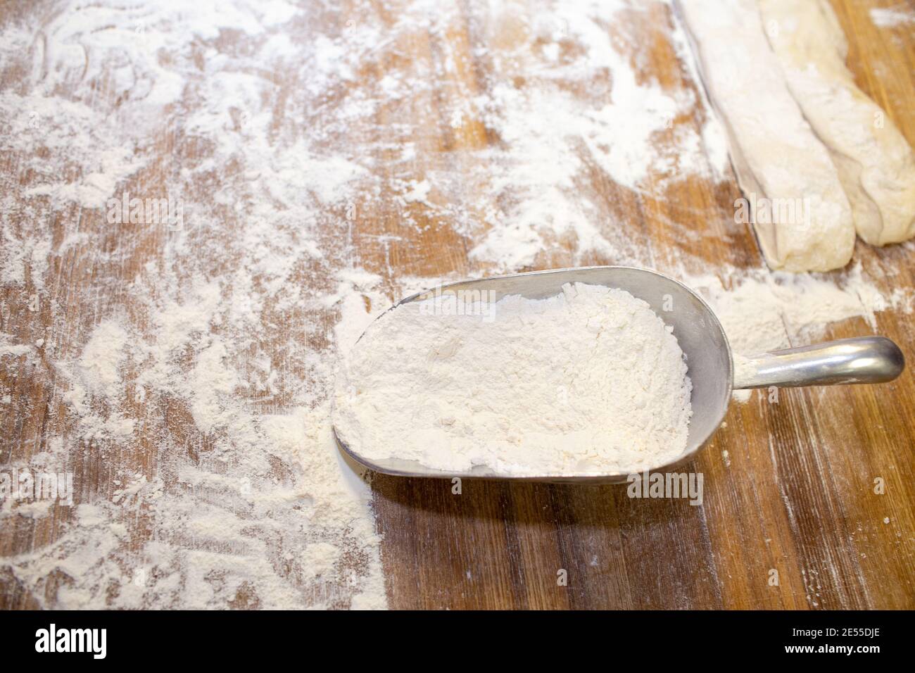 Farina di grano su un tavolo di legno e un misurino. Foto Stock