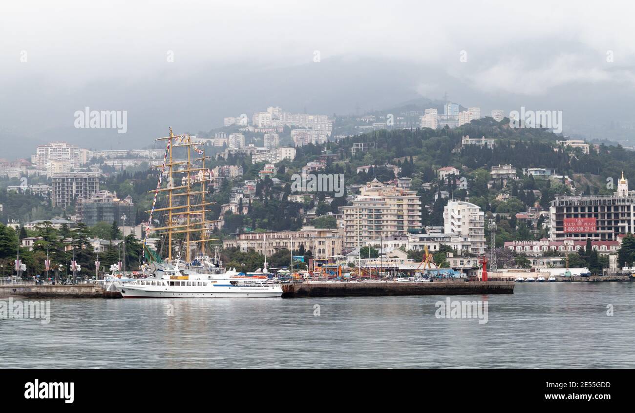 Yalta, Crimea - 8 maggio 2018: Vista costiera del porto di Yalta. Costa Sud della Penisola di Crimea circondata dal Mar Nero. La gente comune cammina il co Foto Stock Yalta, Crimea - 8 maggio 2018: Vista costiera del porto di Yalta. Costa Sud della Penisola di Crimea circondata dal Mar Nero. La gente comune cammina il co Foto Stock