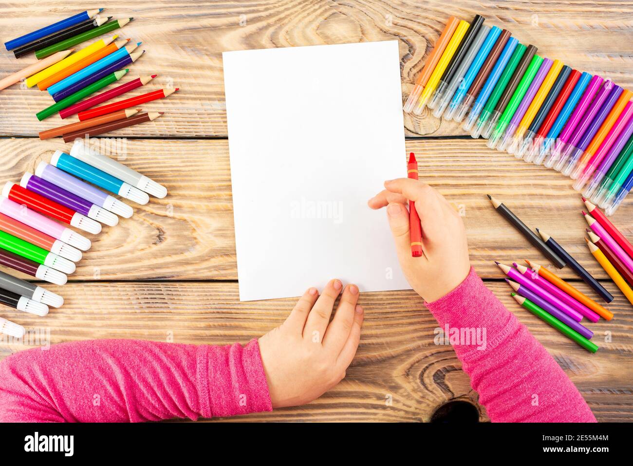 La bambina si prepara a dipingere su un foglio di carta vuoto. Il disegno è  fatto