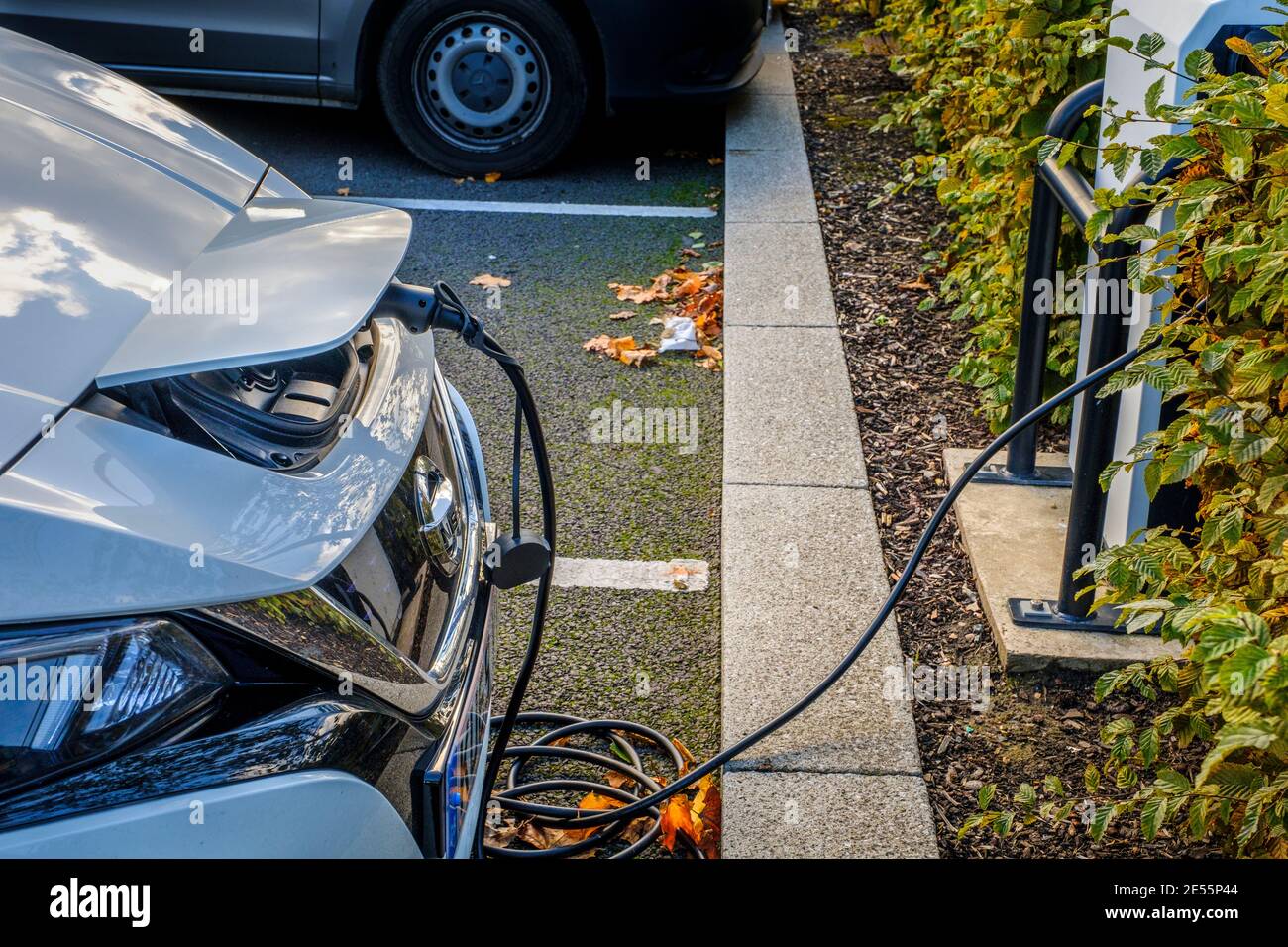 Ricarica di un'auto elettrica in un parcheggio. Foto Stock