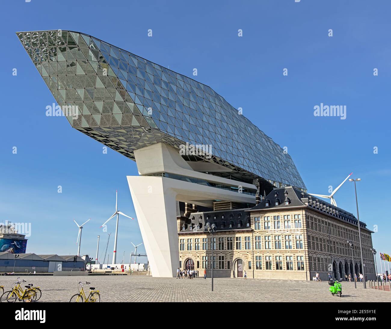 Edificio dell'autorità portuale di Anversa di Zaha Hadid, con piazza con persone e biciclette di fronte. Foto Stock