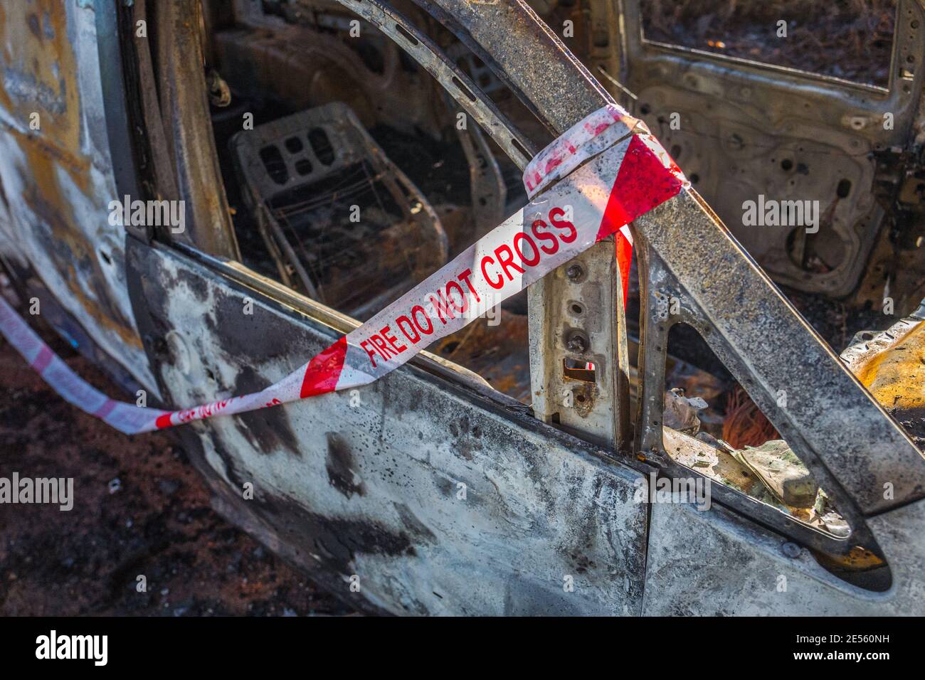 Incendio non incrociare il nastro adesivo su un veicolo bruciato. Foto Stock