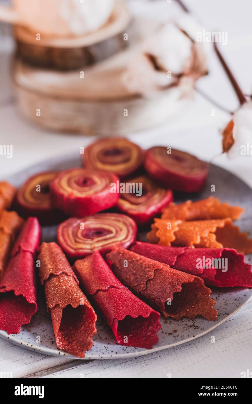 Panini di frutta pastiglia. Rotoli di caramelle Apple, patatine. Frutta secca e grattugiata. Dolcezza utile. Dessert alimentare. Spuntino fatto in casa. Frutta degidrata. Naturale Foto Stock