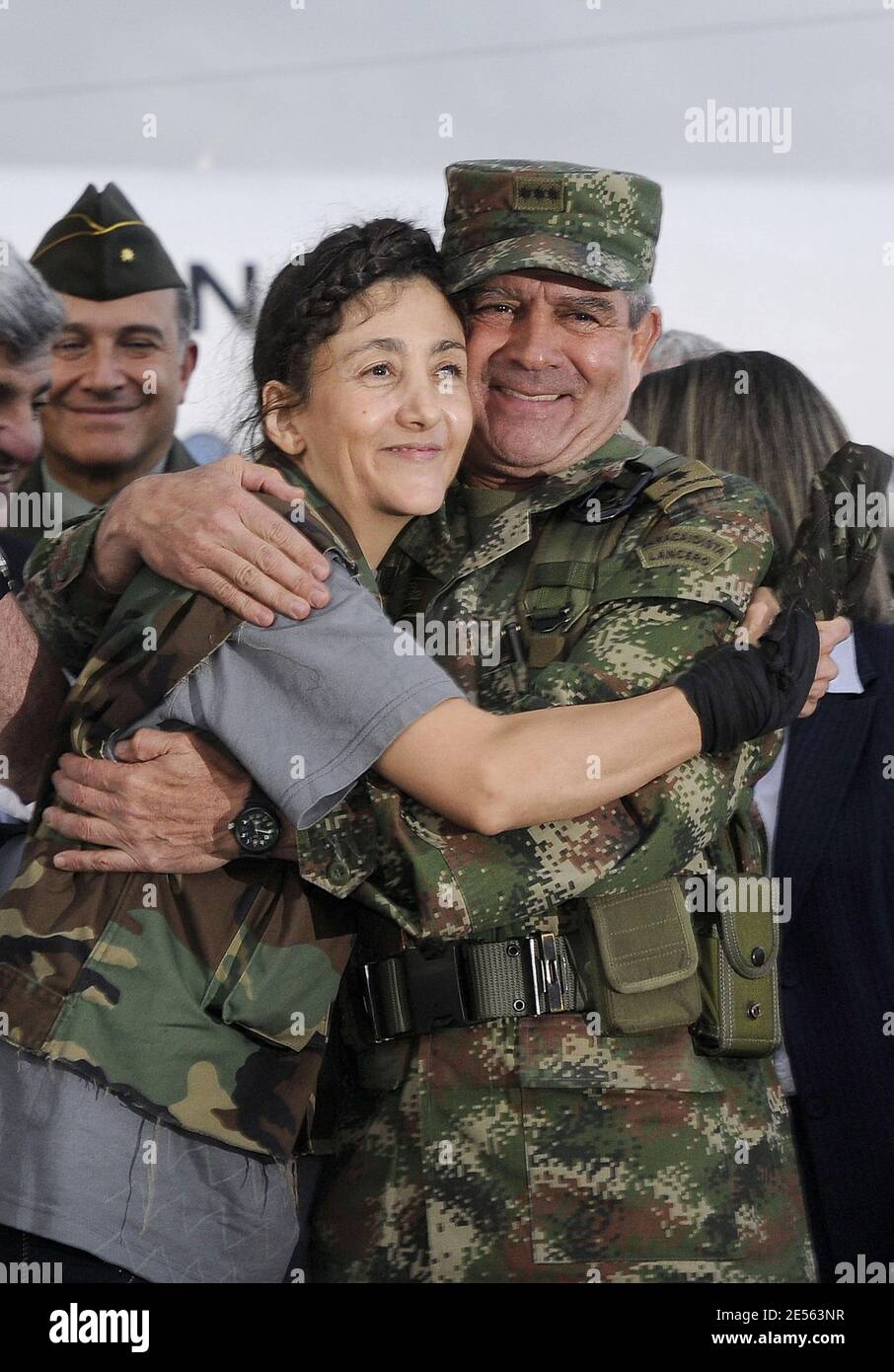 Il comandante dell'esercito colombiano, il Gen. Mario Montoya, destra, ed ex ostaggio Ingrid Betancourt come ministro della Difesa Juan Manuel Santos si trova oltre dopo l'arrivo di Betancourt ad una base militare a Bogotà, Colombia il 2 luglio 2008 dopo essere stato salvato da sei anni di prigionia. Betancourt è uno dei 15 ostaggi salvati dall'esercito colombiano dalle forze armate rivoluzionarie della Colombia, o FARC. Foto di Reina/ABACAPRESS.COM Foto Stock