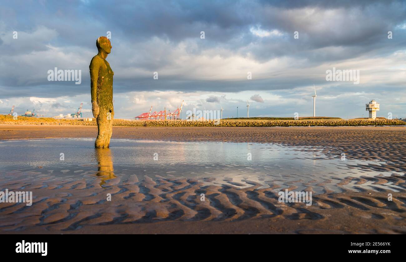 Iron Man in una piscina d'acqua a bassa marea sulla spiaggia di Crosby vicino a Liverpool. Foto Stock