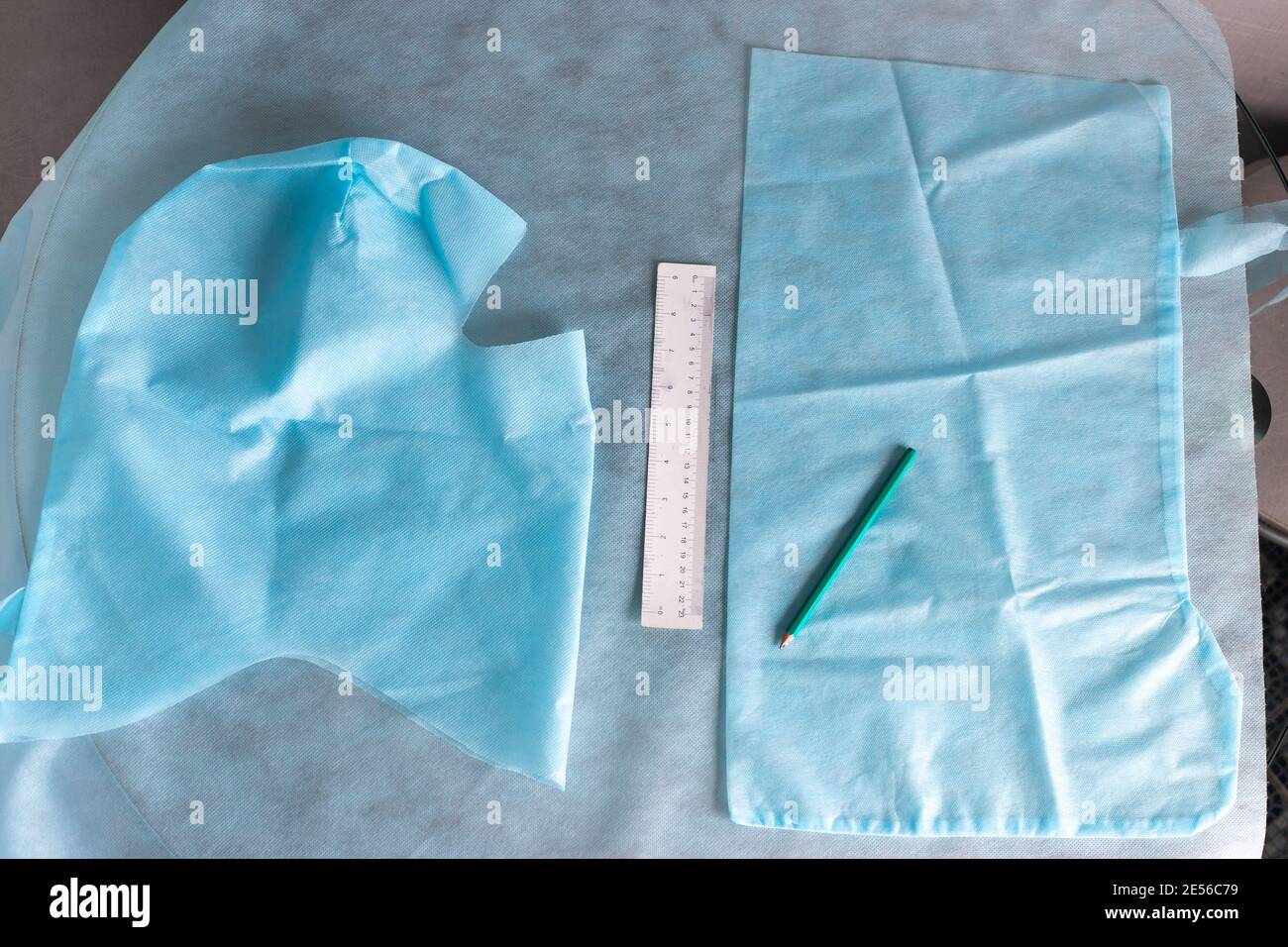 modello di abbigliamento medico protettivo, sartoria di copriscarpe e casco da tessuto medico blu, mancanza di oggetti di abbigliamento medico utilizzati nel coronavirus Foto Stock