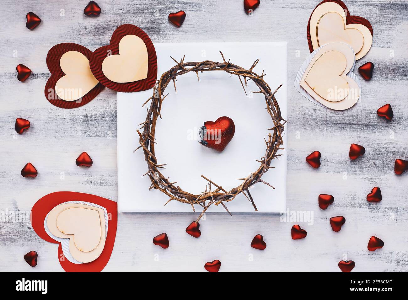 San Valentino carta corona di spine e cuore rotto su una tela vuota con una varietà di cuori. Immagine ripresa dalla vista superiore. Foto Stock