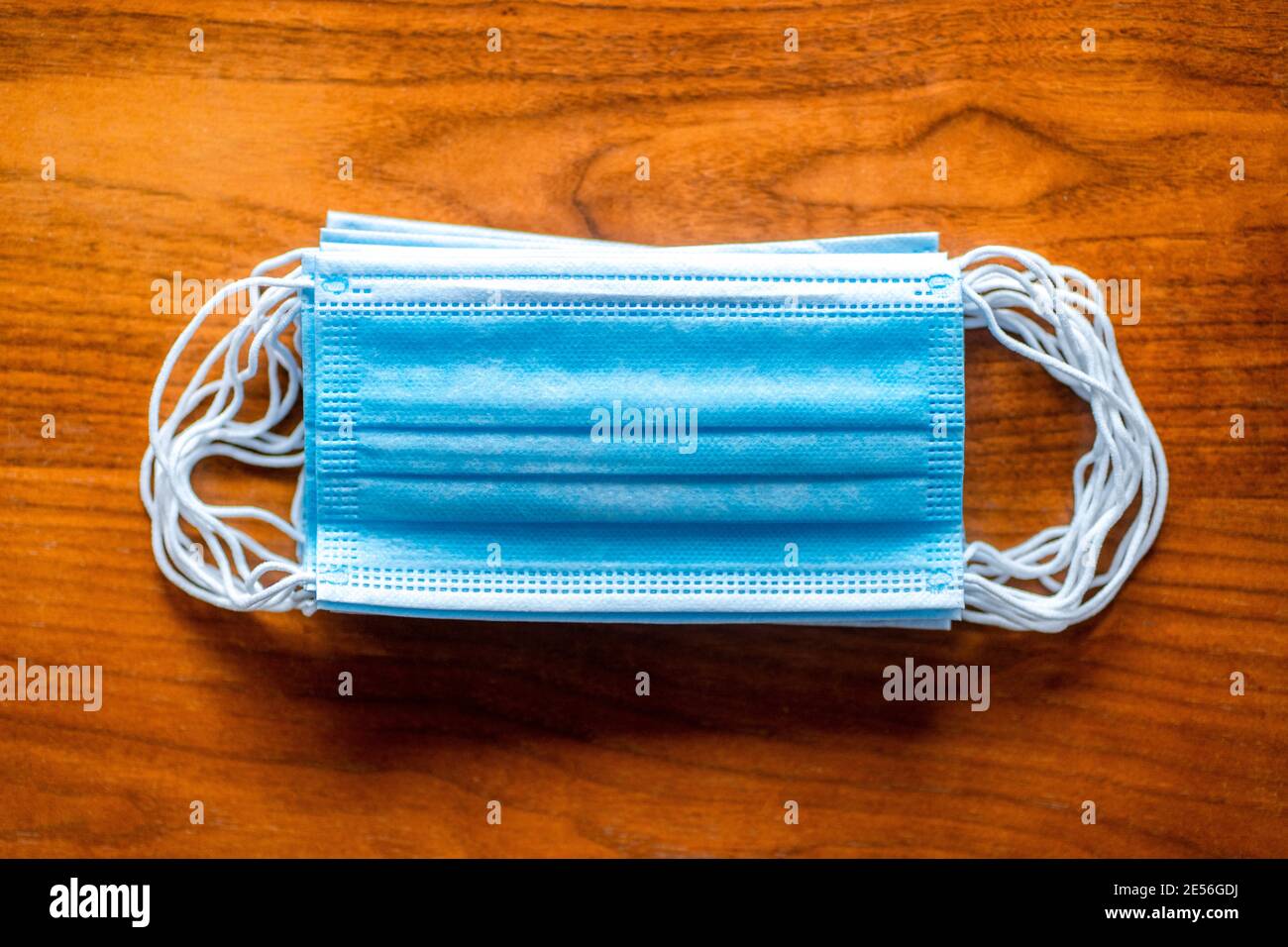 Covid-19 medico chirurgico maschera viso. Protezione della bocca del coronavirus su fondo di legno Foto Stock