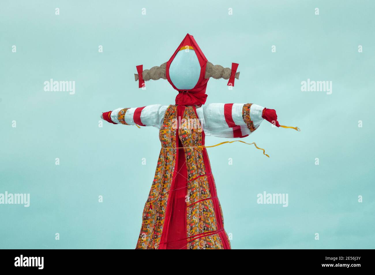 Grande bambola tradizionale contro il cielo blu con le nuvole durante Shrovetide in Russia. Simbolo dello Scarecrow di fine inverno Foto Stock
