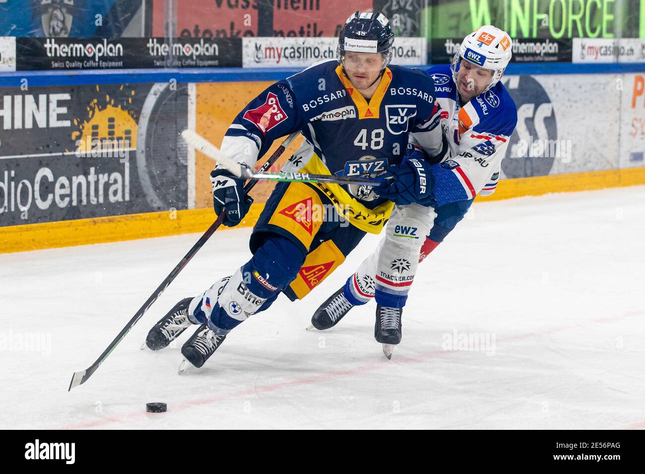 Battaglia tra Carl Klingberg n° 48 (EV Zug) e n° 4 Patrick Geering (ZSC) durante la partita di hockey su ghiaccio della National League Regular Season tra EV Zug e i Lions ZSC il 26 gennaio 2021 nella Bossard Arena di Zug. Credit: SPP Sport Press Photo. /Alamy Live News Foto Stock