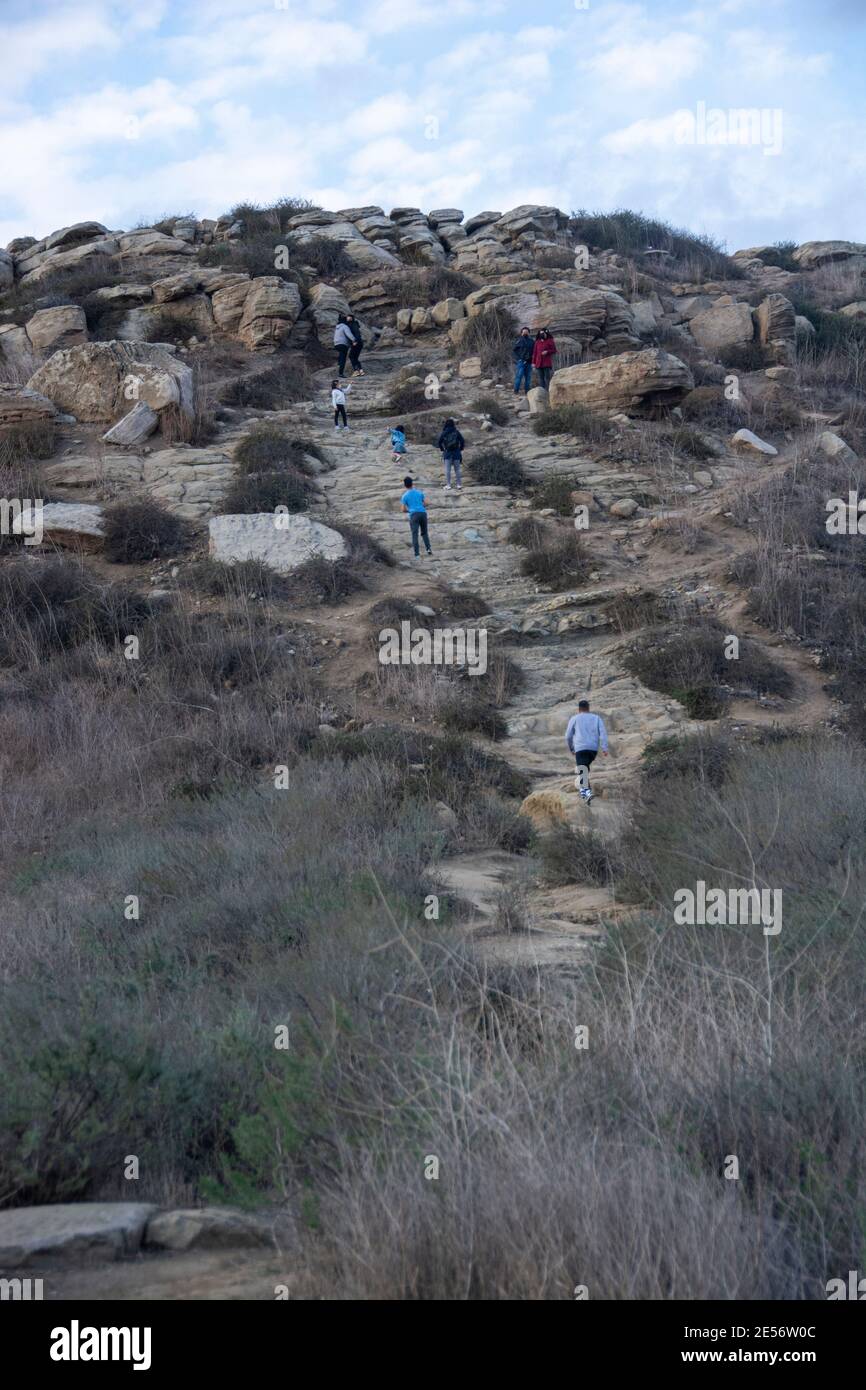 Un gruppo misto di escursionisti che attraversano un sentiero su una collina. Foto Stock