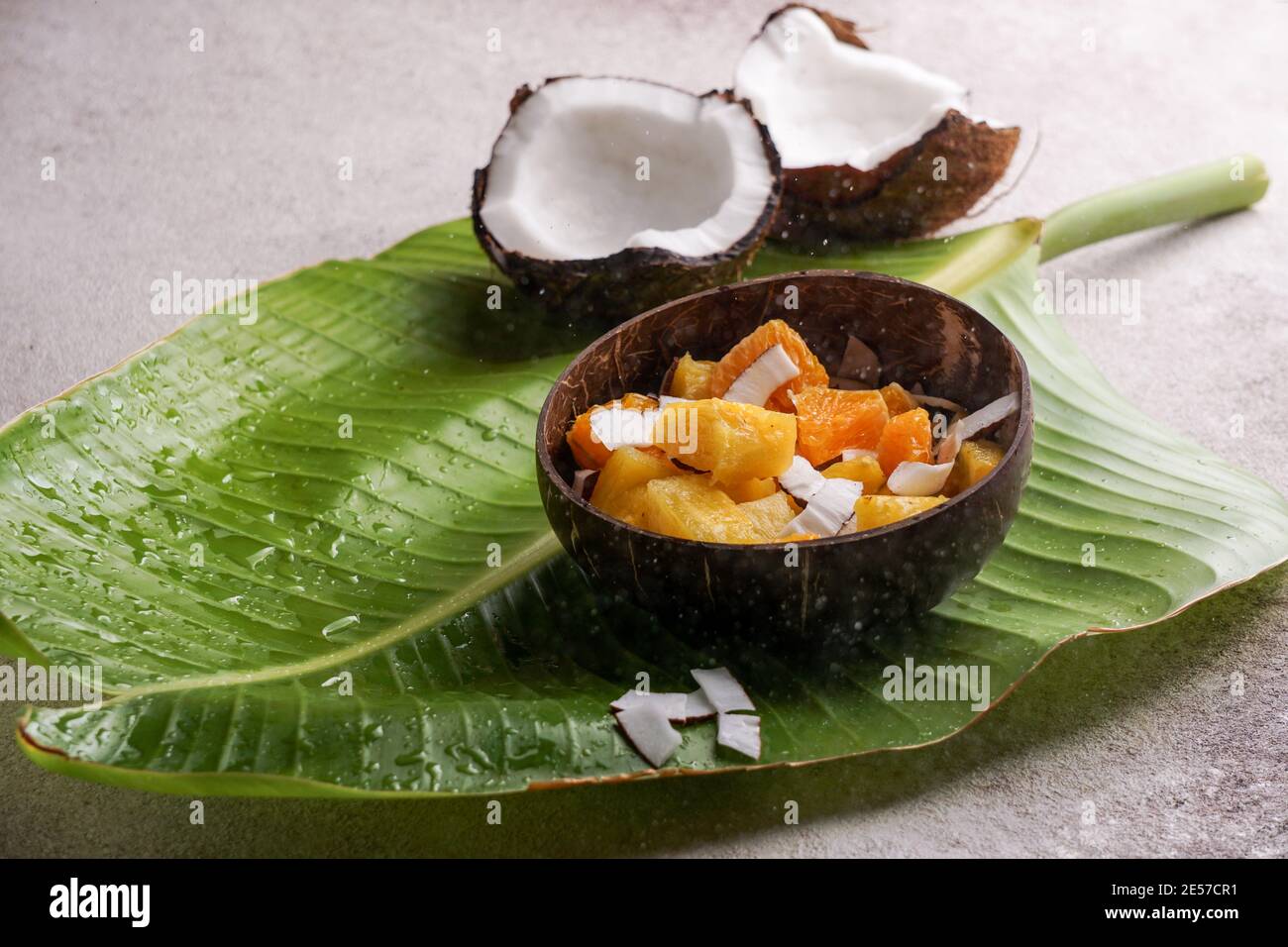 insalata tropicale di ananas fresco con cocco, sulla foglia di banana, ciotola di cocco Foto Stock