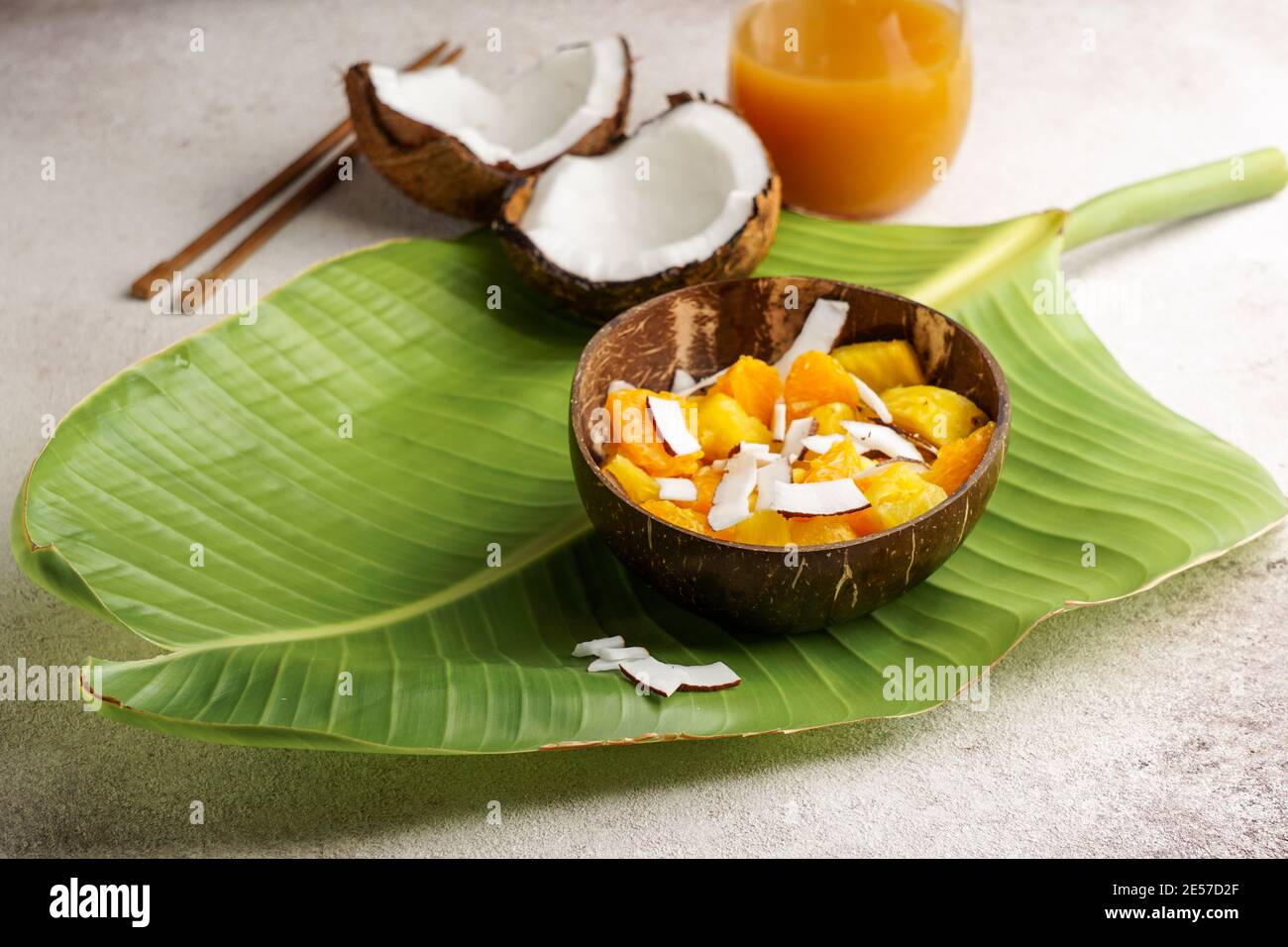 insalata tropicale di ananas fresco con cocco, sulla foglia di banana, ciotola di cocco Foto Stock