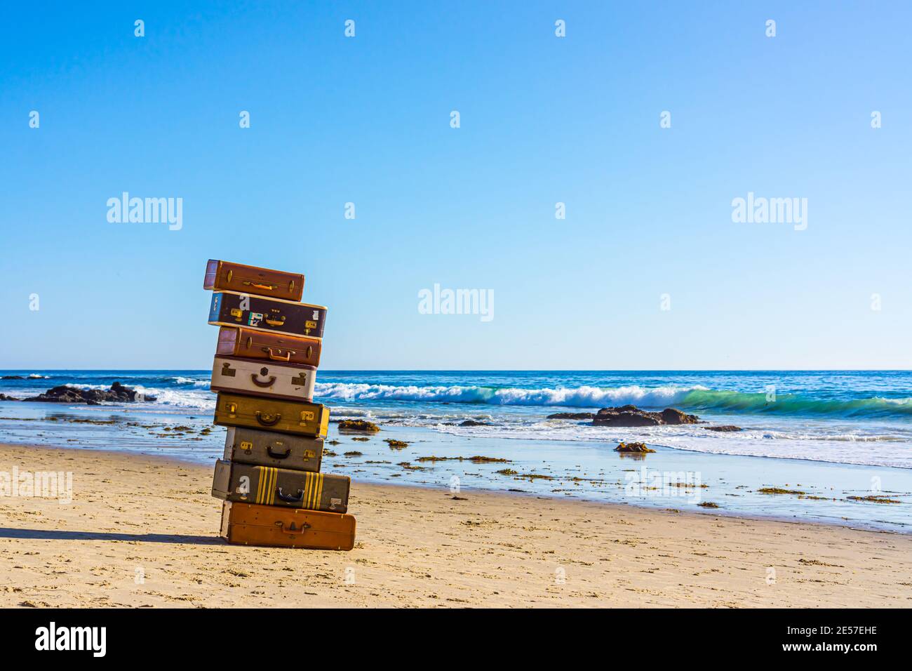 Bagagli vecchi impilati insieme sulla spiaggia Foto Stock