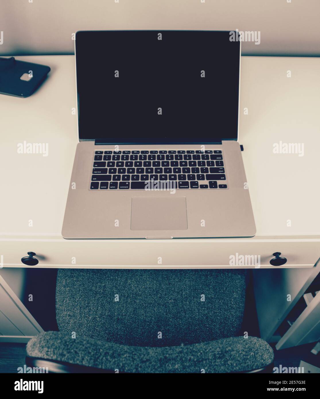 Postazione di lavoro con scrivania e computer portatile. Foto Stock