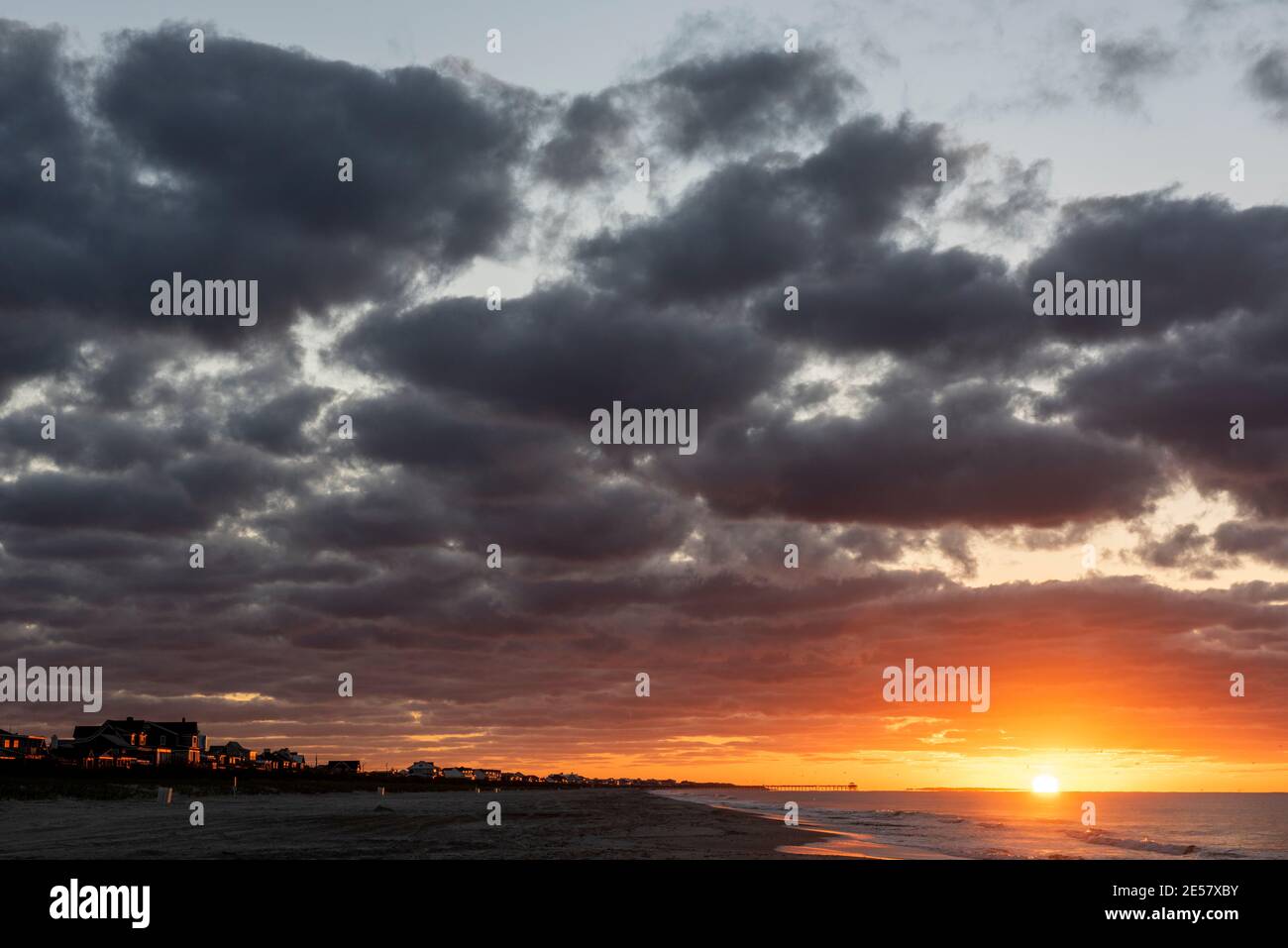 Le nuvole di stratocumuli riflettono il bagliore arancione e rosa dell'alba mattutina ad Atlantic Beach, Carolina del Nord. Foto Stock