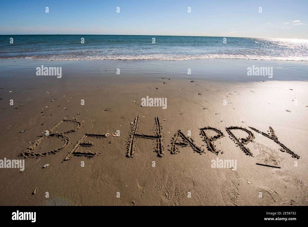 Le parole SONO FELICE scritto nella sabbia vicino al mare. Foto Stock