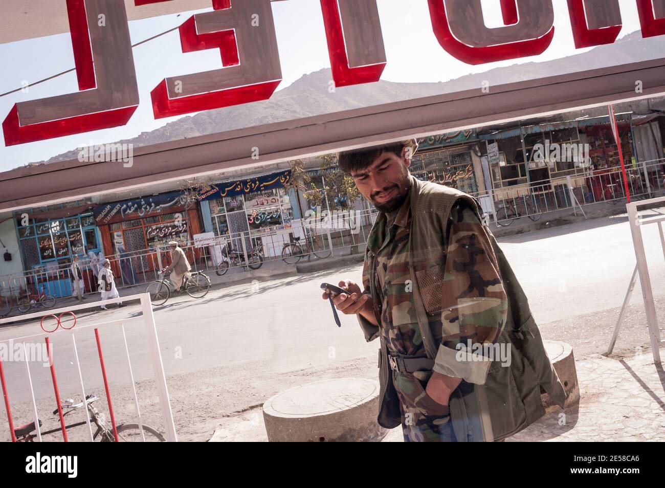 Una guardia di sicurezza si trova all'esterno di un hotel che guarda la strada a Kabul, Afghanistan. Foto Stock