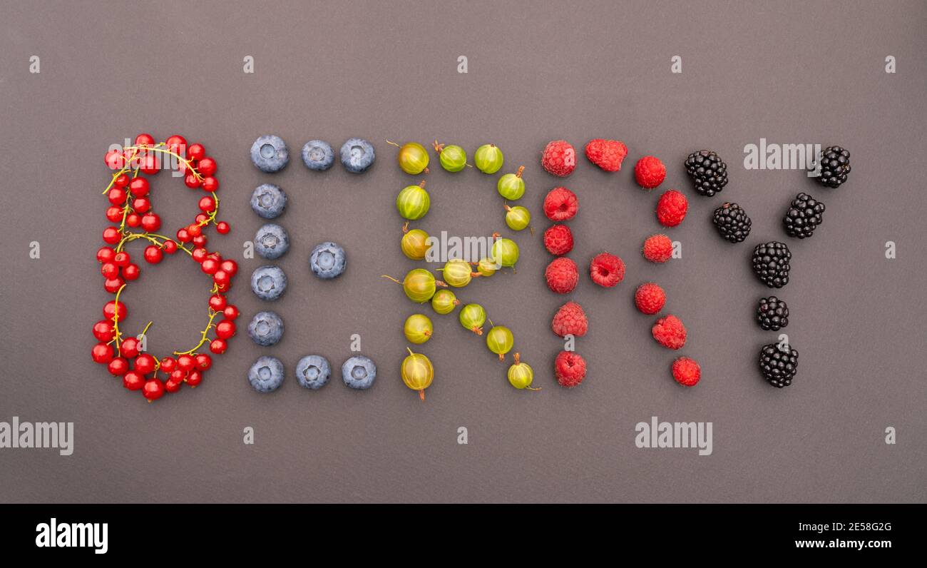 L'iscrizione BERRY è fatta di bacche mature, succose, dolci su fondo nero. Vari di bacche multicolore disposti sotto forma di lettere Foto Stock