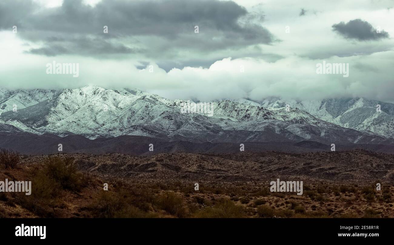 Montagne innevate sullo sfondo del deserto Foto Stock