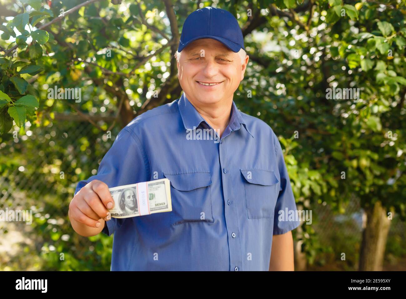 Un uomo anziano che tiene una pila di soldi Foto Stock